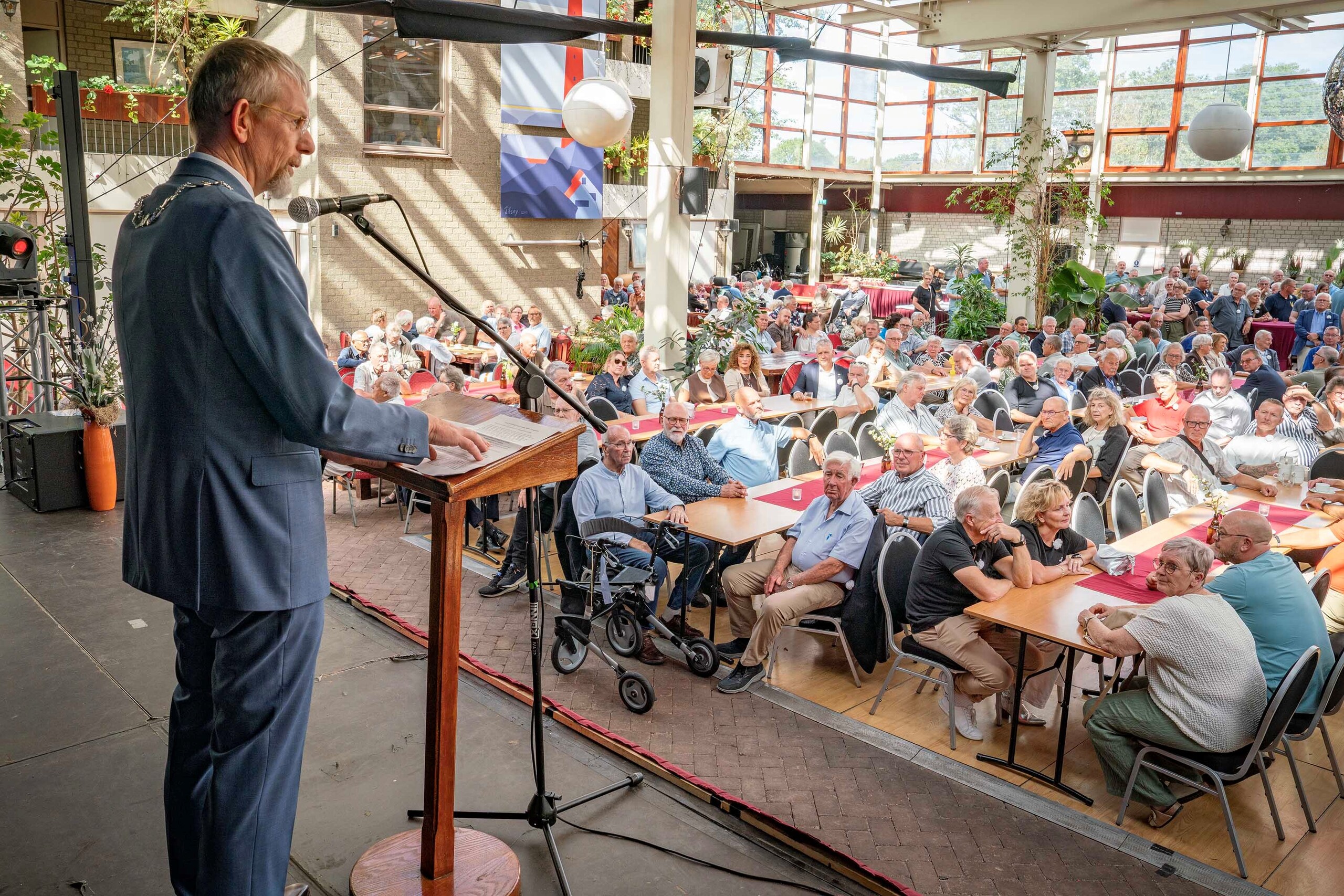 Burgemeester de Boer houdt toespraak op podium voor publiek
