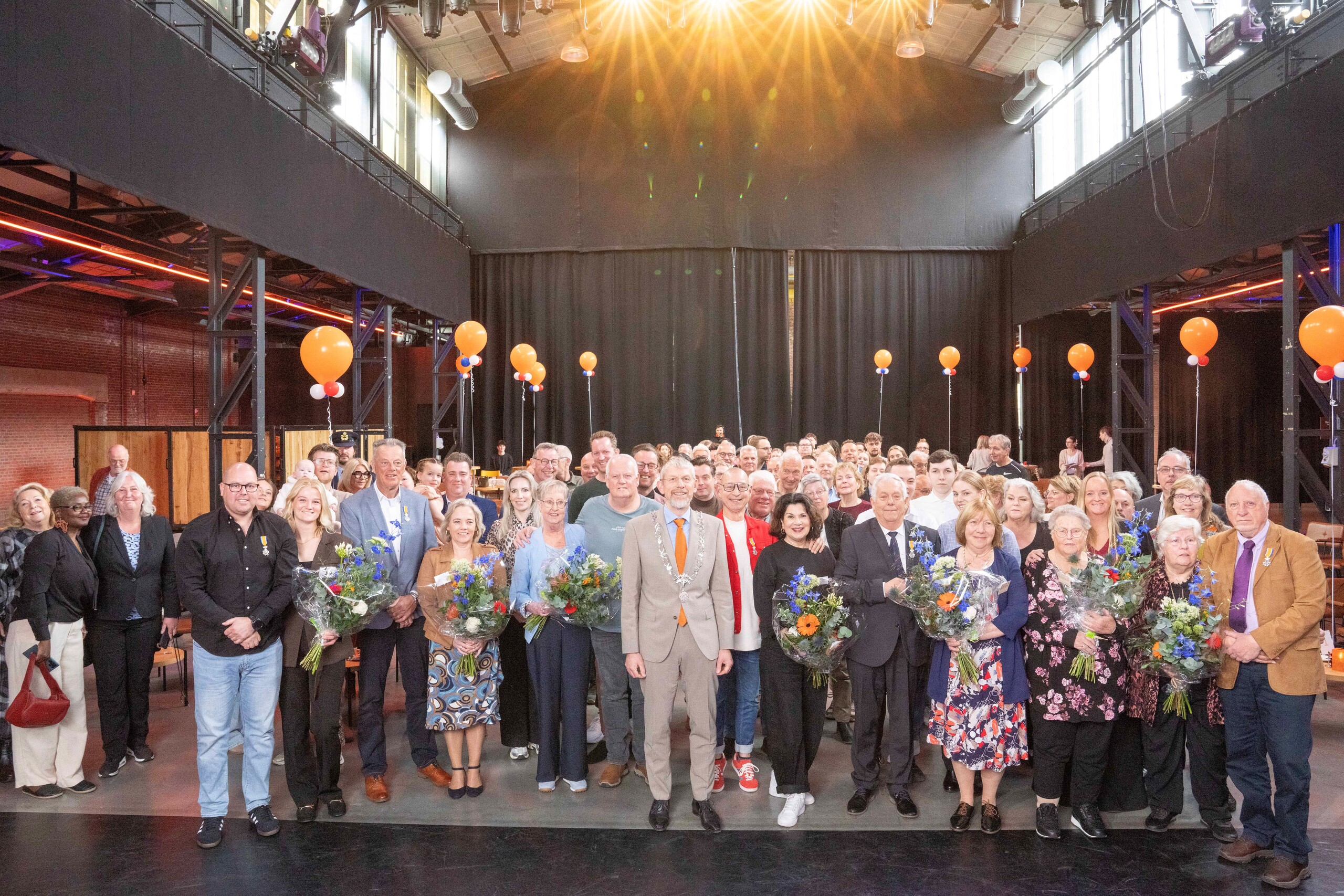 De gedecoreerden en burgemeester de Boer in theater de Kampanje