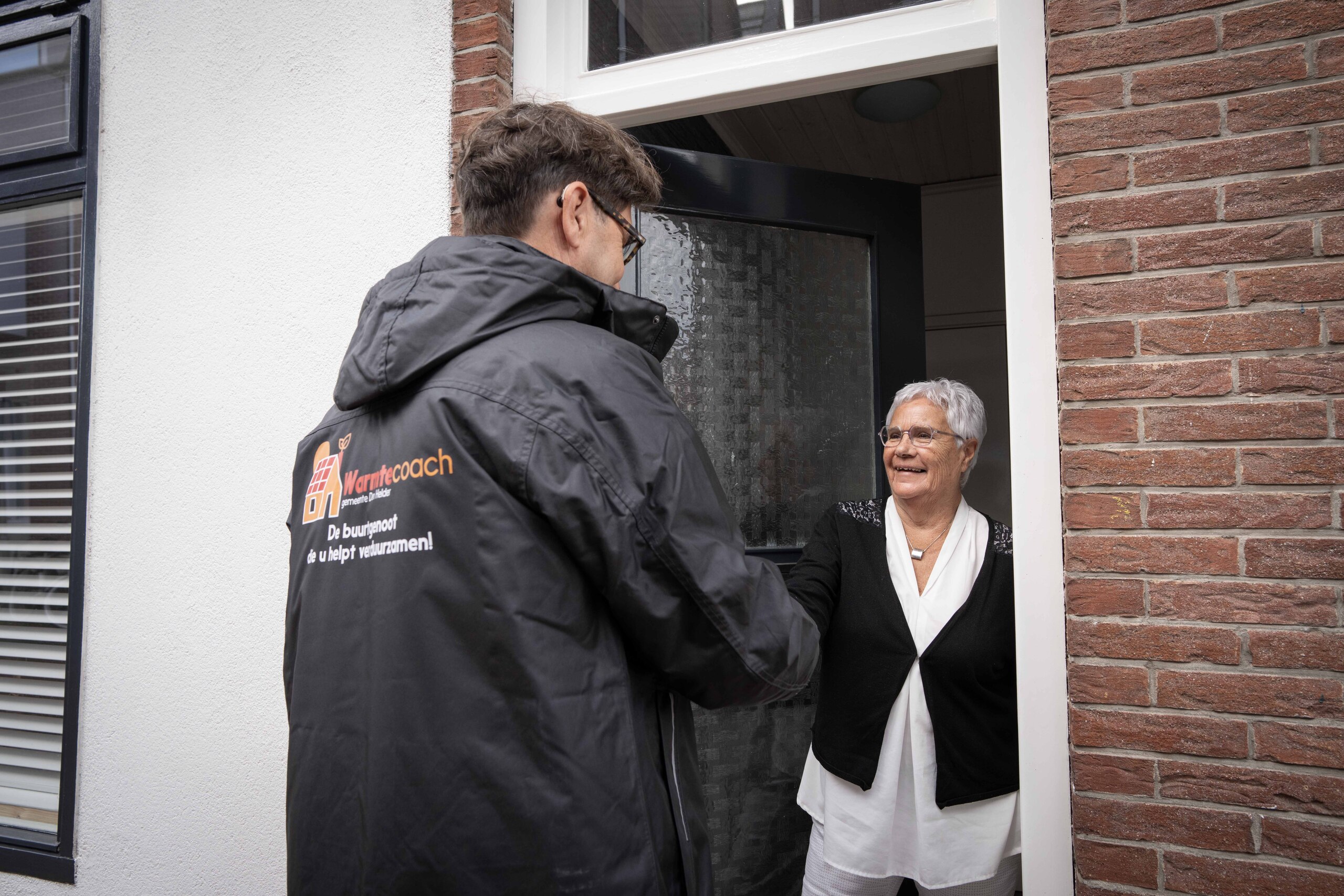 Warmtecoach aan de deur bij een mevrouw