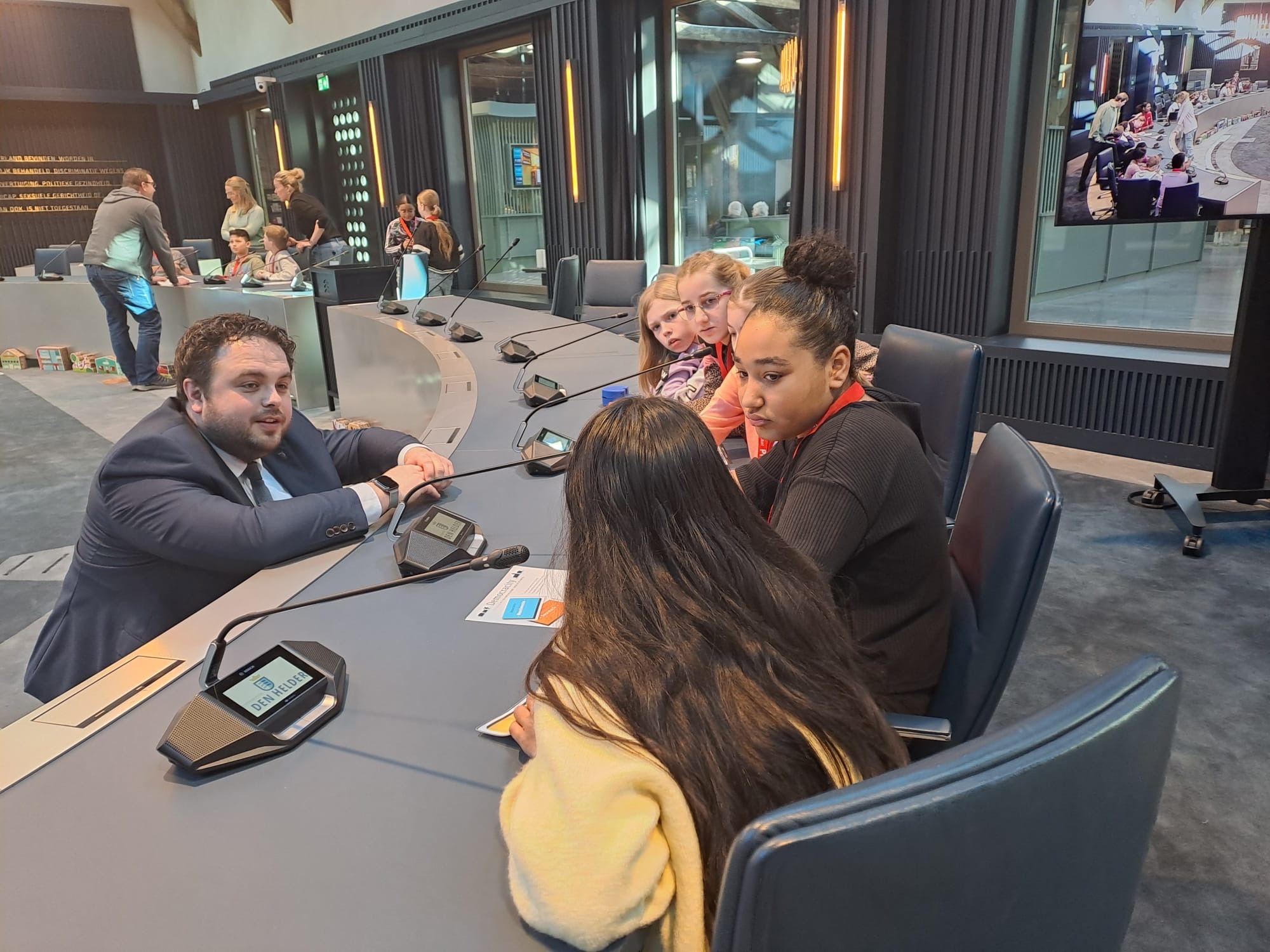 Niels Nanning en kinderen van groep 8 van basisschool De Fontein uit Den Helder aan vergadertafel